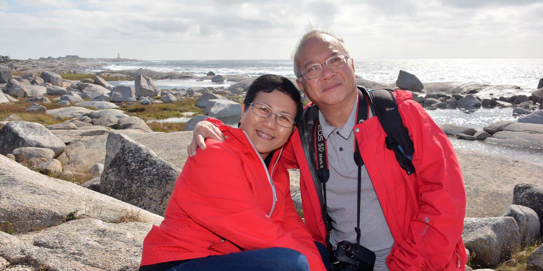 A couple embraces on the rocks near Peggy's Cove, Nova Scotia - photo by Geordie Mott and Picture Perfect Tours.